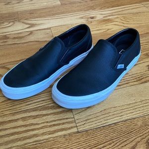 Women’s black leather Vans.